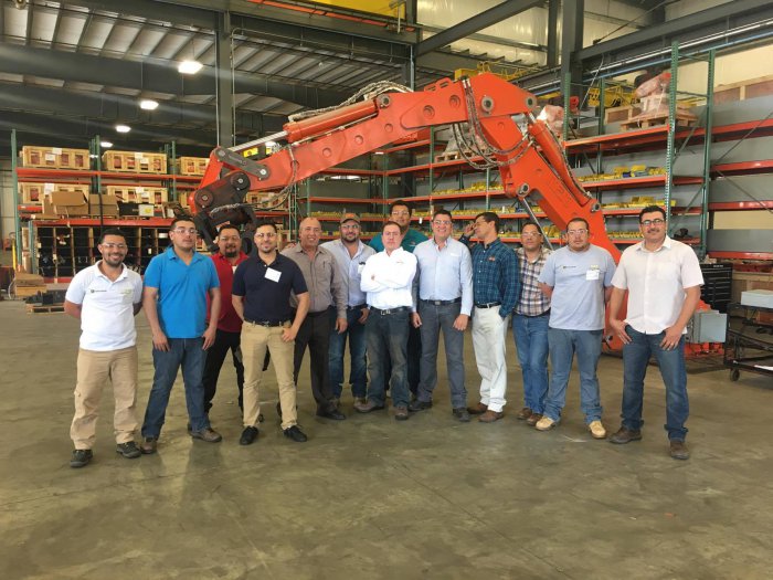 International service conference attendees in front of B7500 pedestal boom system